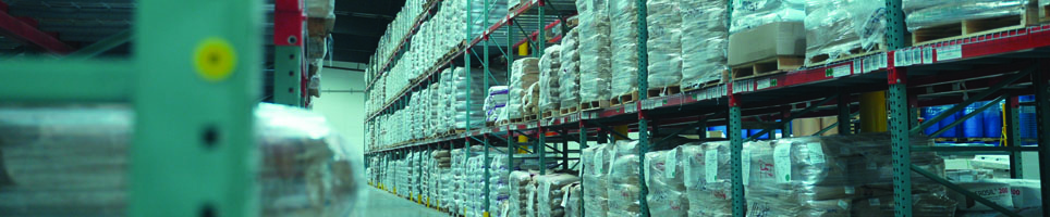 A large machine lifting white bags of material.