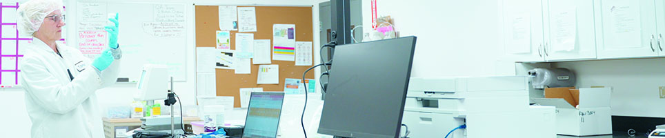 Someone holding a clipboard and quality control checklist in a lab.
